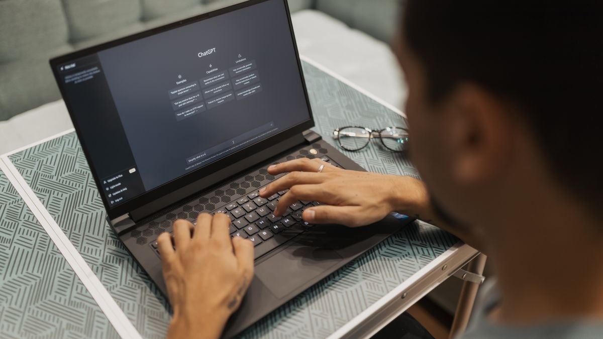 Person using a laptop to work with an AI assistant in a modern workspace