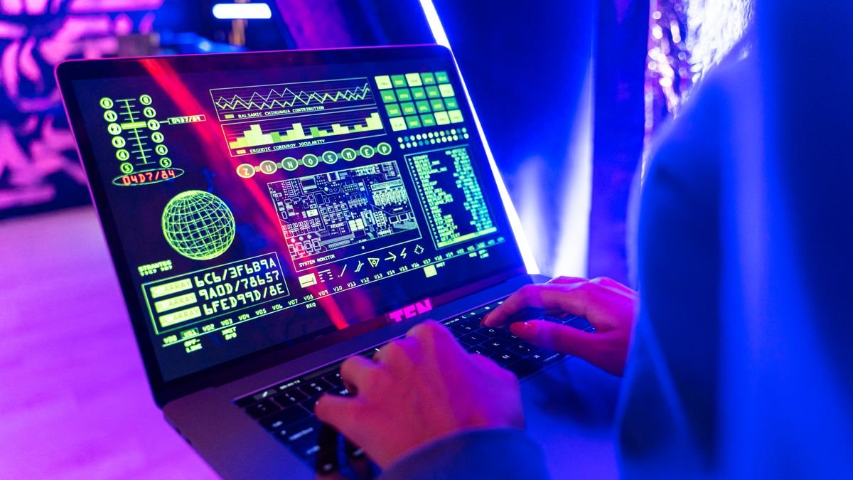 Person using a laptop with a digital data display in a modern technology workspace