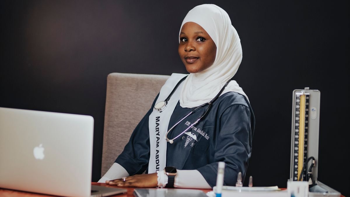 Graduate seated at a desk with a laptop