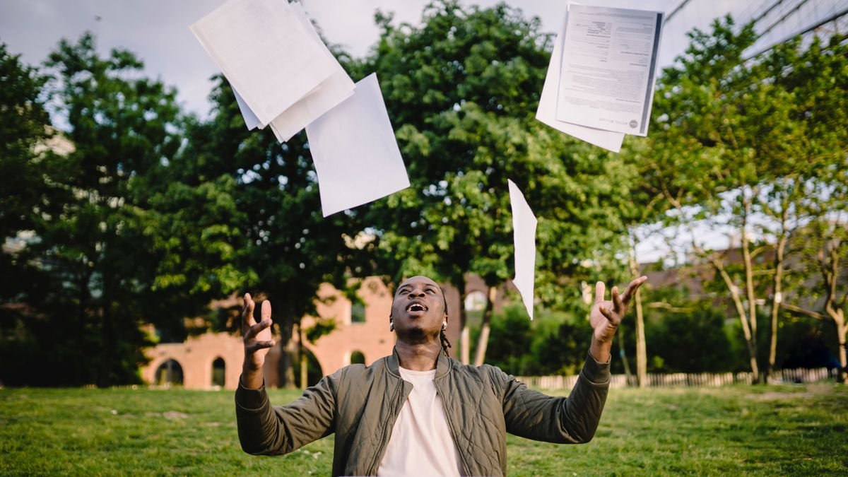 Graduate with papers and a laptop representing education and job preparation