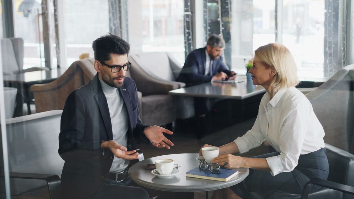 Two professionals having an informational career conversation at a table