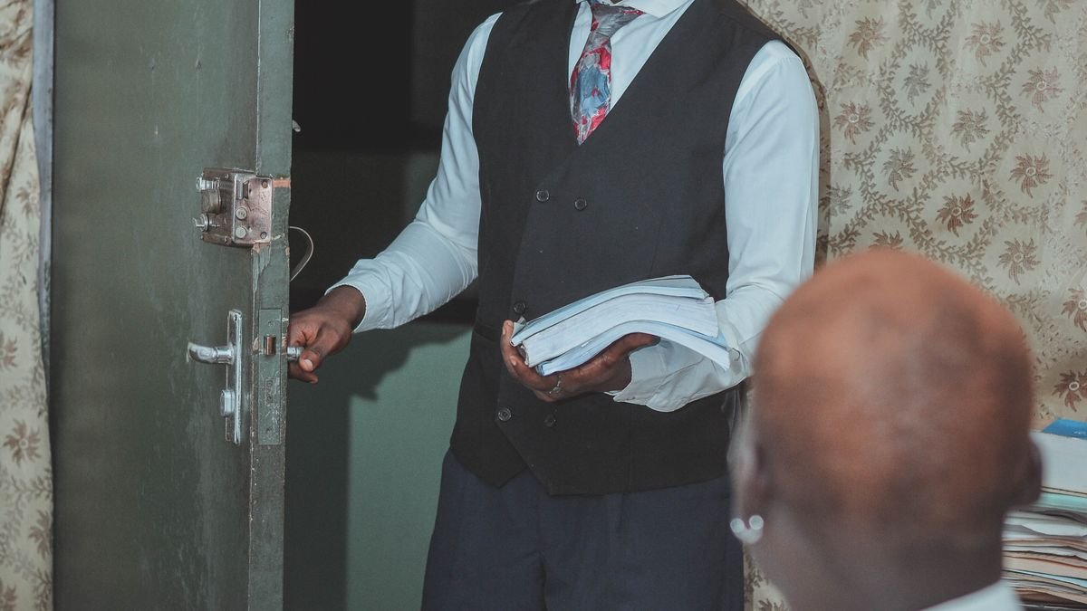 Young professional entering an office with documents for an early-career opportunity