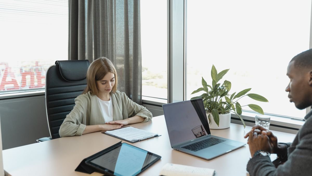 Candidate sitting across from an interviewer in a professional office interview