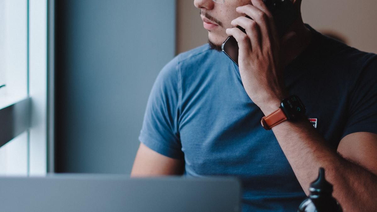 Young professional reviewing job notifications while working on a laptop