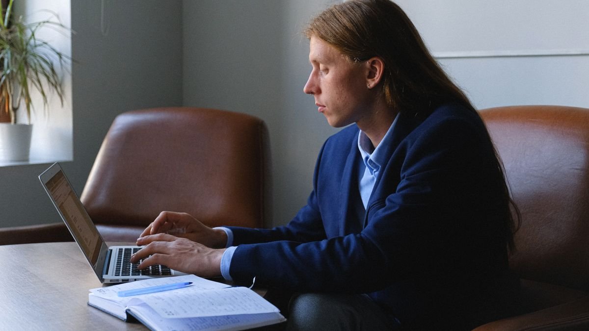 Person editing a professional profile while working on a laptop