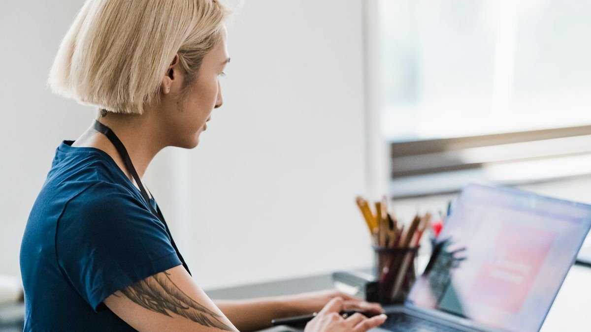 Young professional working on a laptop in an office while building practical skills