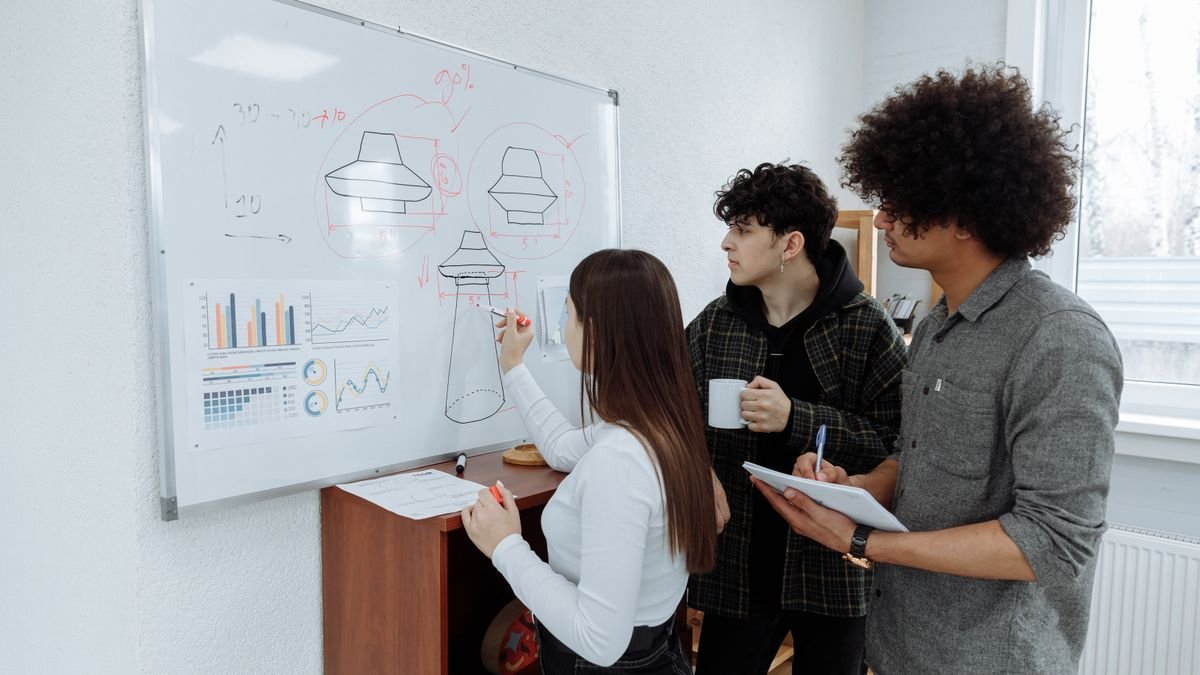 Young professionals brainstorming ideas together on a whiteboard