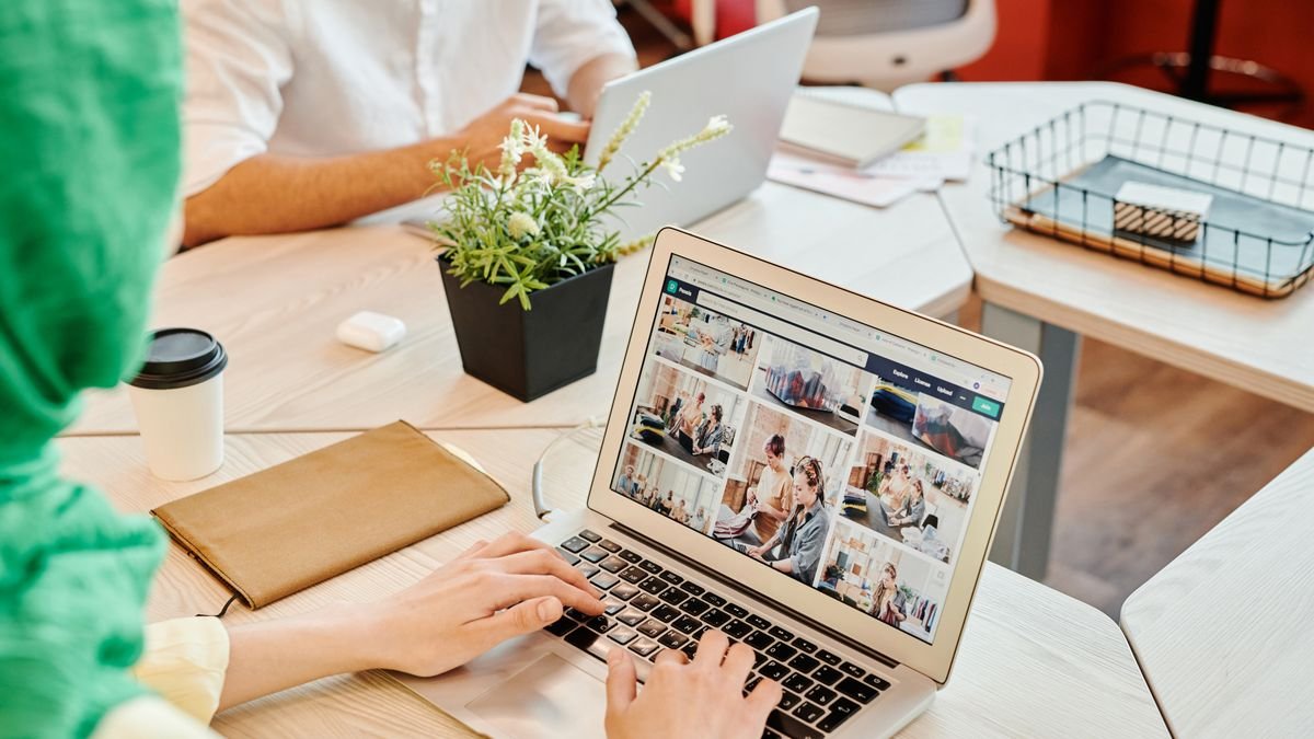 Office professional typing on a laptop at a shared workspace