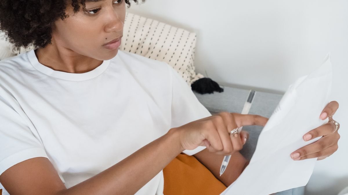 Job seeker reviewing notes and documents while preparing a first-job application