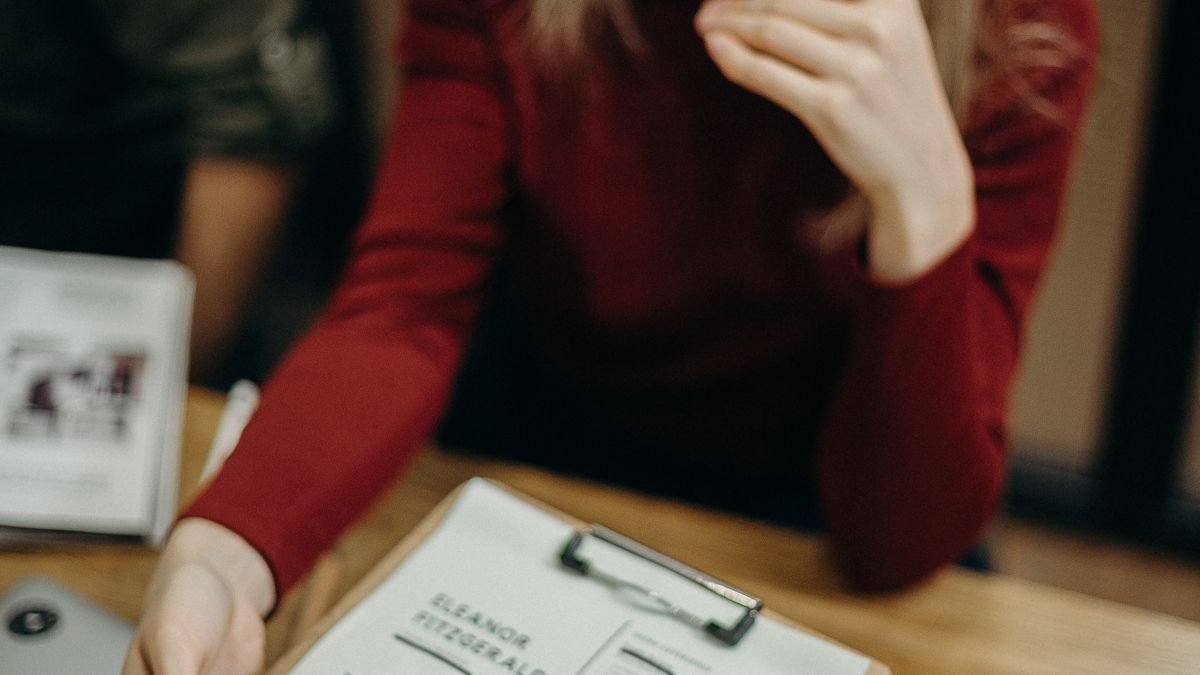 Woman reviewing a resume on a clipboard at a desk