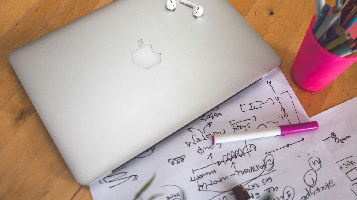 Organized desk with laptop, notes, and pens for reviewing skills