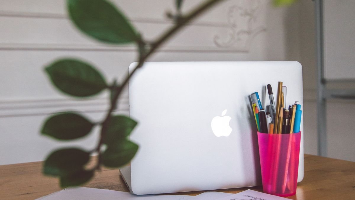 Laptop and papers arranged on a desk for resume planning