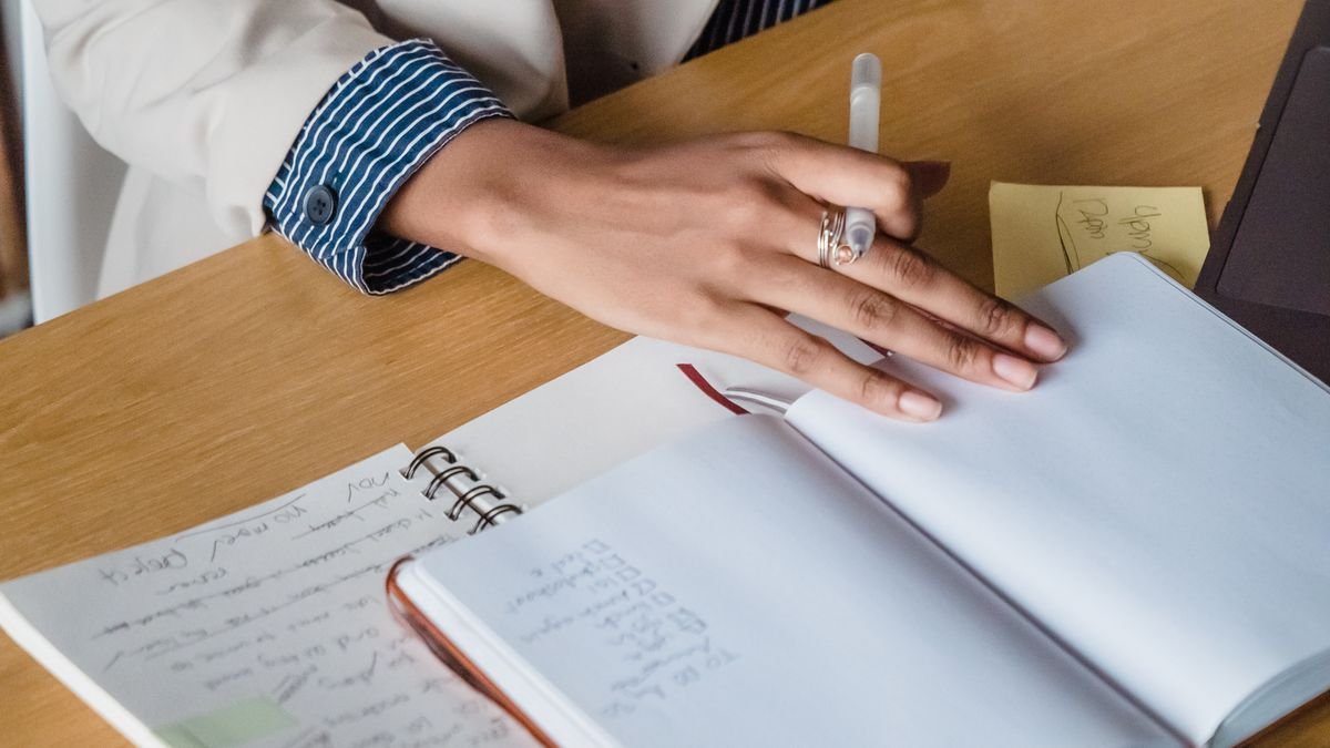 Professional planning work with a notebook, papers, and sticky notes at a desk