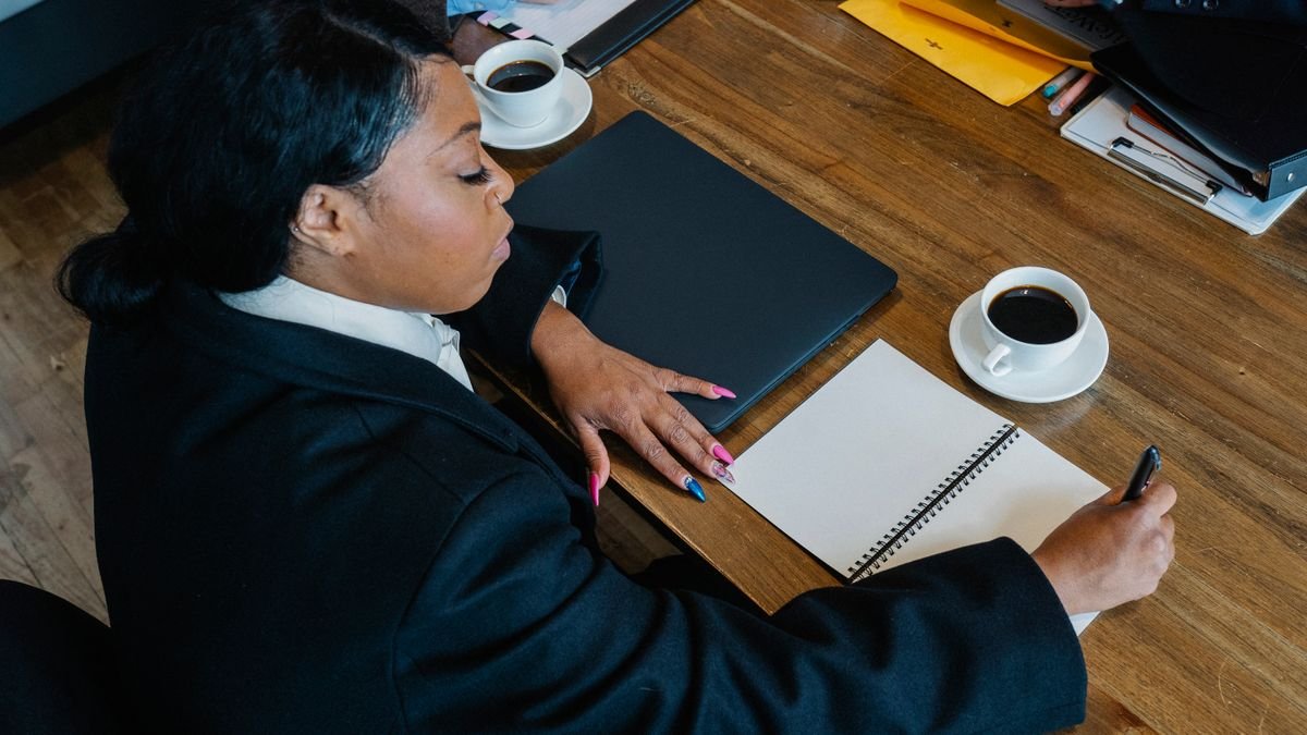 Business professional taking notes while organizing tasks during a meeting