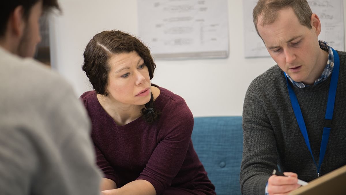 Colleagues communicating face to face during an office meeting